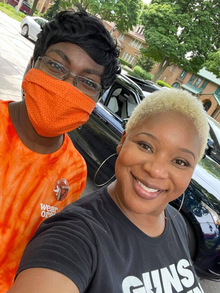 Jenevia Blanks, masked, poses for a selfie with another volunteer
