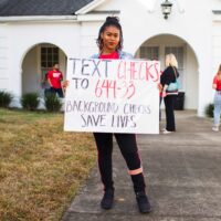 Woman holds a sign on Background Checks