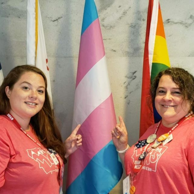 Dannette and Shelby Fadness stand next to a transgender flag