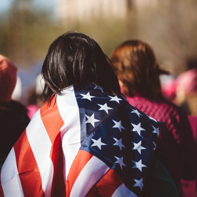 A person with an America flag over their shoulders