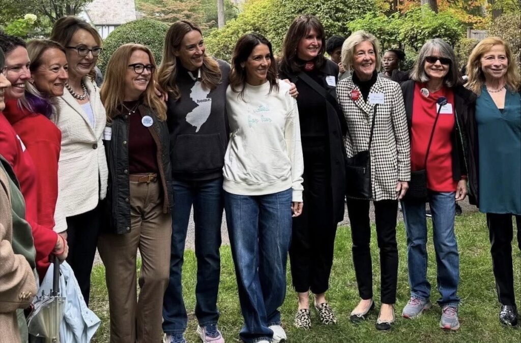 9 volunteers pose for a photo with Mikie Sherrill and Congresswoman Gabby Giffords during an election event.
