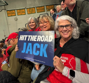 Three Moms Demand Action volunteers smile for a photo while at a candidate event in New Jersey. They are holding a sign that reads 