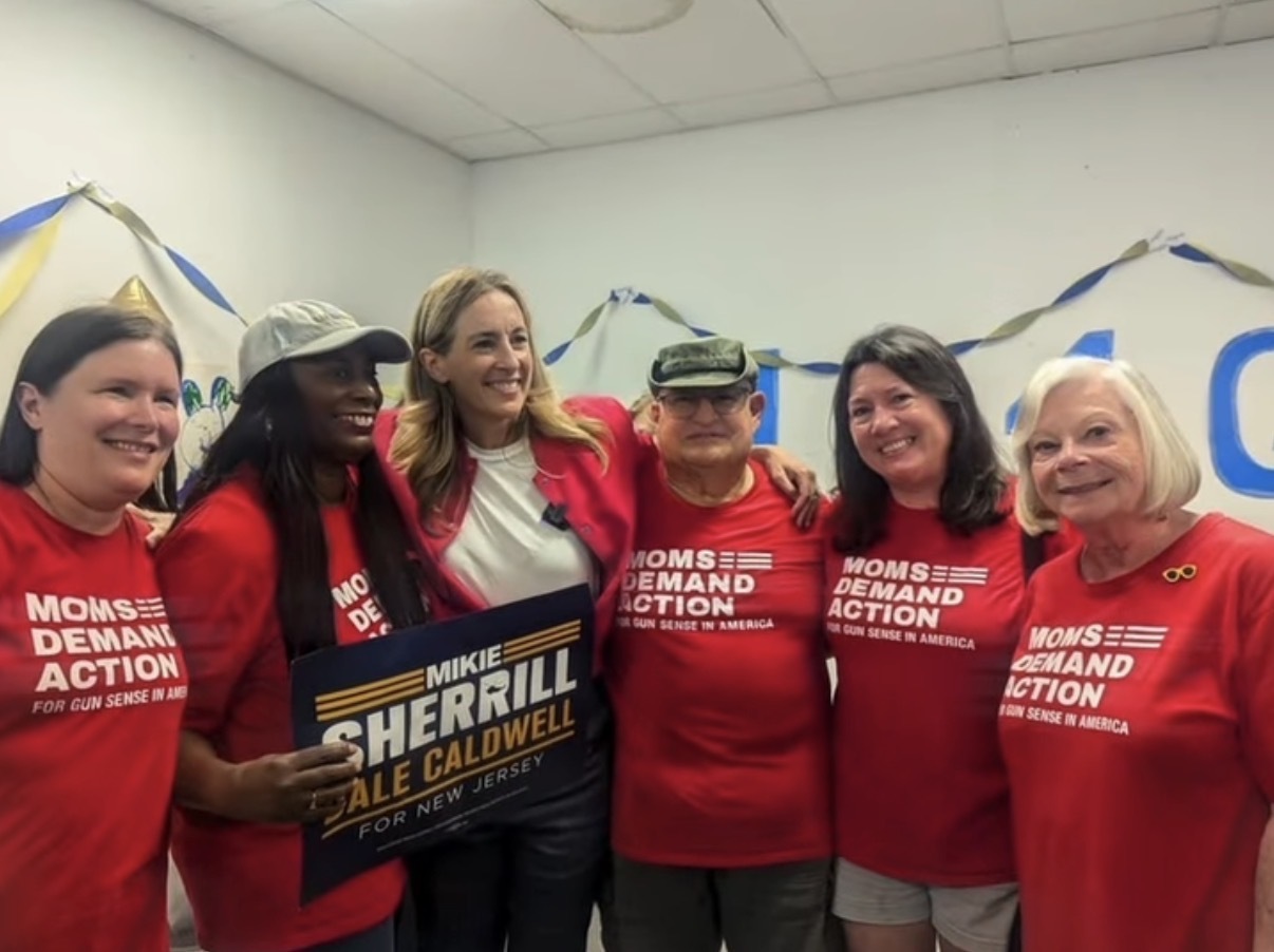 Five Moms Demand Action volunteers smile for a photo with Mikie Sherrill during an election event.